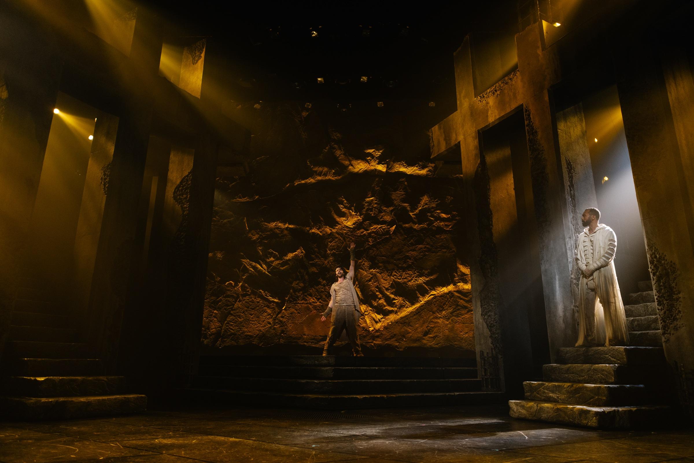 The Jesus Christ Superstar set in gold light, a lone figure standing at the foot of the steps