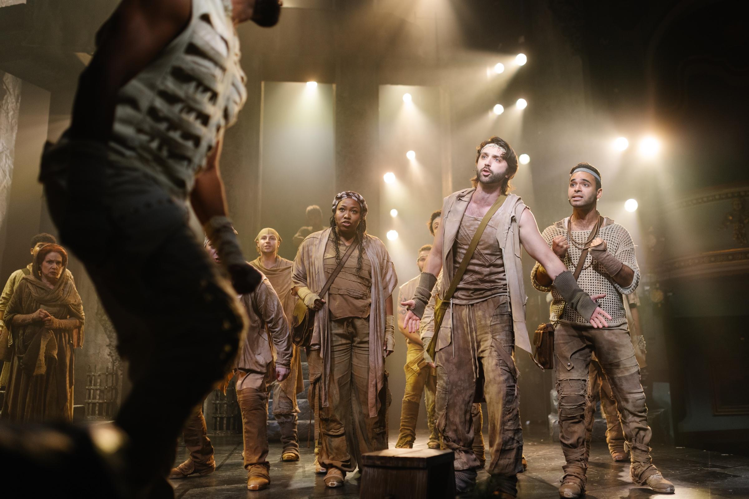 Shane Lonergan among the company of Jesus Christ Superstar, lit by a cluster of held candles